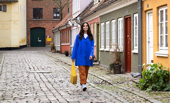 kvinde går med hund og pakke