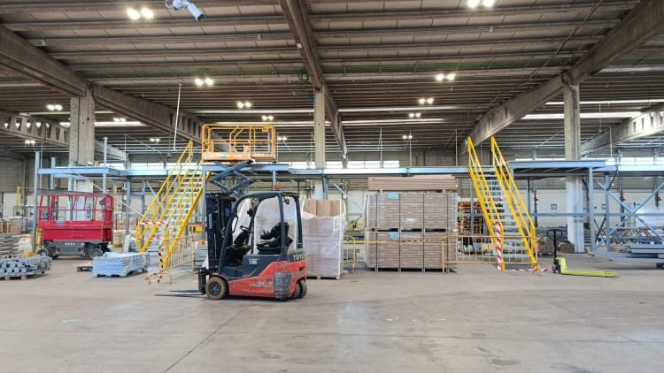 Interior de almacén logístico con carretilla elevadora y zona de clasificación de mercancías