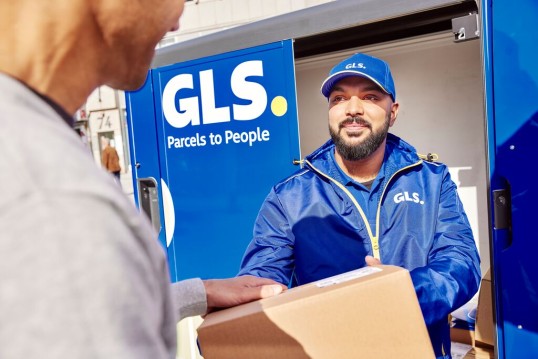 GLS työntekijä ojentaa paketin asiakkaalle