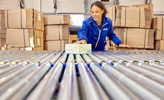 Conveyor belt and cardboard boxes at the background