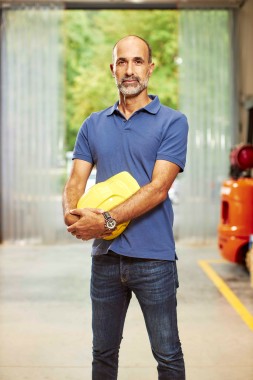 middle aged man holding a yellow hard hat