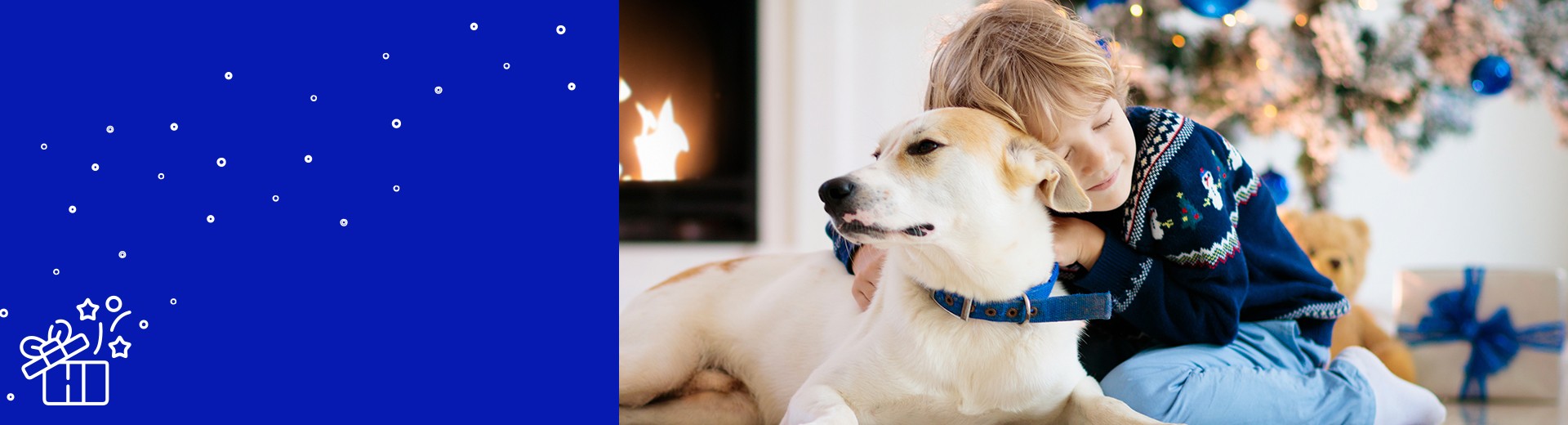 bambino e cane davanti all'albero di Natale