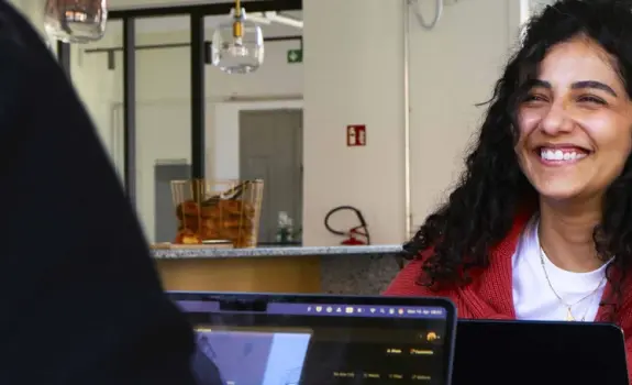 A woman smiling while using a computer.
